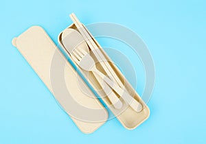 The Yellow set of plastic spoons, forks and chopsticks kit set on blue background