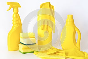 Yellow set of products for washing and cleaning. Rubber gloves, chemical bottles, sponges and rags.