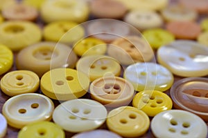 Yellow sewing buttons on a wood table