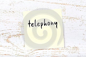 Yellow sheet of paper with word telephony. Reminder concept