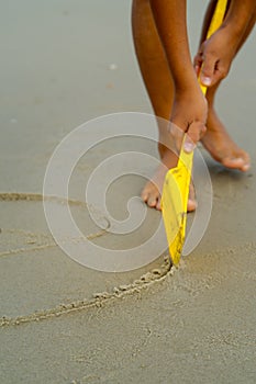 yellow shovel on sand, drawng something photo
