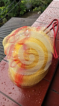 Yellow Shower puff with red line, under the rain, background red floor and fibre cement