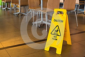 Yellow sign that alerts for wet floor in the restaurant.Thailand.