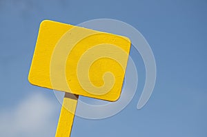 Yellow Sign on Bright Blue Cloudy Sky