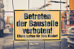 Yellow sign in german: Betreten der Baustelle verboten! Eltern h