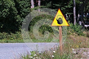 Yellow sign with kettle or teapot on the side of the road.