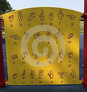 Yellow sign language alphabet guide board on children`s playground