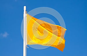 Yellow signal flag at sky background