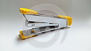 Yellow and Silver Iron Stepler on White Background