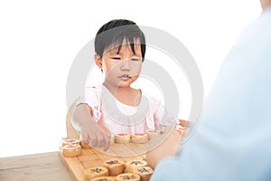 The yellow-skinned little girl is playing Chinese chess with an adult seriously