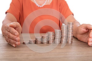 Yellow-skinned middle-aged woman pampers a row of increasing dollar coins with both hands