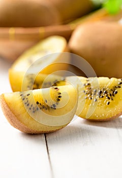 Yellow sliced kiwi fruit on white wood