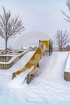 Yellow slide on snowy playground in Daybreak Utah