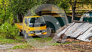 A yellow small truck near a private house