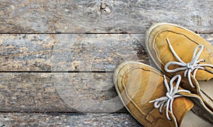 Yellow sneakers from an aerial view on wooden floors.