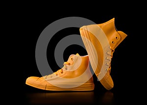 Yellow sneakers on a black background.