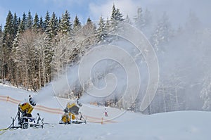 Yellow snow maker machine snow gun, snow cannon at ski slopes resort - standard equipment device for making snow to create bette