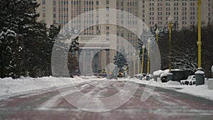 Yellow snow plow removes snow after heavy snowfall in the city during the day