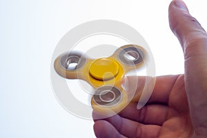 Yellow spinner spinning in the hands of a teen