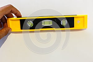 Yellow spirit level over white