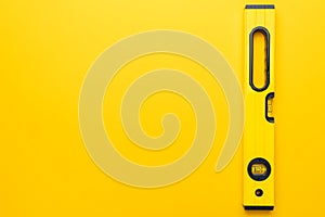 Yellow spirit level on the yellow background with some copy space