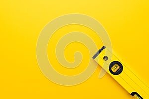 Yellow spirit level on yellow background with some copy space