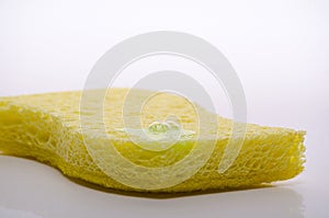 Yellow sponge for washing dishes with a drop of detergent, soap bubble, isolated on white background
