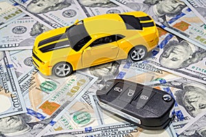 Yellow sport car with keys on money background