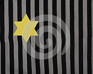 Yellow Star of David on striped fabric. To remember the victims of the Holocaust and genocide.