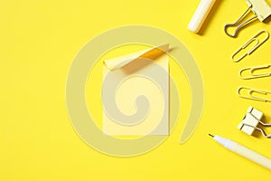 yellow stationery equipment and blank yellow note pad stick on vivid yellow background
