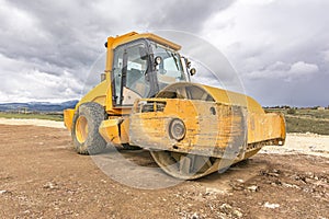 Yellow steamroller performing ground leveling work