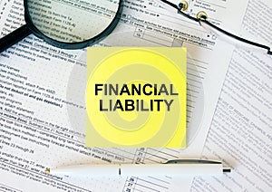 Yellow sticker with text Financial Liability on financial docs
