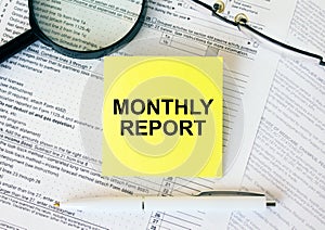 Yellow sticker with text Monthly Report on financial docs