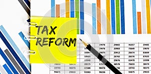 Yellow sticker with text TAX REFORM on chart with pencil . It can be used as a business and financial concept