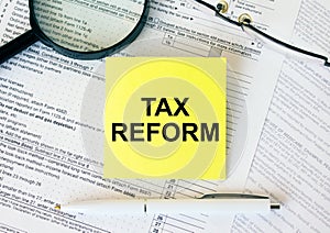 Yellow sticker with text Tax Reform on financial docs