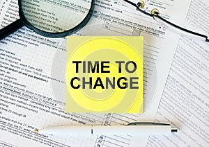 Yellow sticker with text Time To Change on financial docs