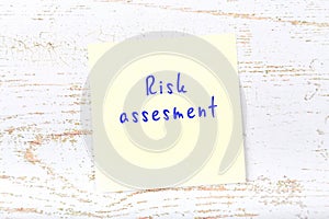 Yellow sticky note with handwritten text risk assesment
