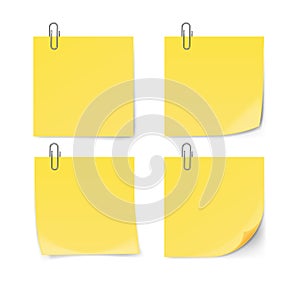 Yellow sticky note with paper clip isolated on white background.