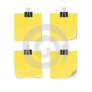 Yellow sticky note with paper clip isolated on white background.