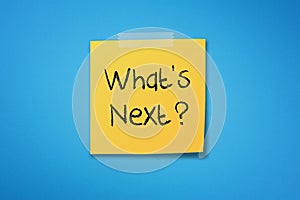 Yellow sticky note paper with what`s next on blue background