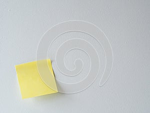 Yellow sticky note on a white wall