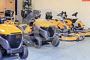 A row of sit on lawn mowers