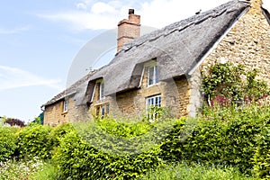 Yellow stone English cottage with thatched roof