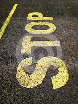 Yellow Stop lettering on asphalt