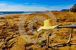 Yellow straw hat on sandy beach