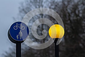 Yellow street lamp and road sign - Separate lanes for pedestrians and cyclists