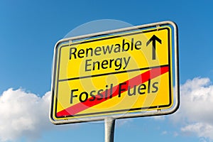 Yellow street sign with renewable energy ahead leaving fossil fuels behind