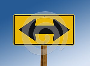 Yellow street sign showing two arrows