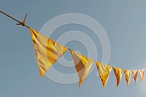 A yellow string of flags is hanging in the sky