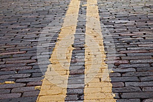 Yellow stripe on brick street